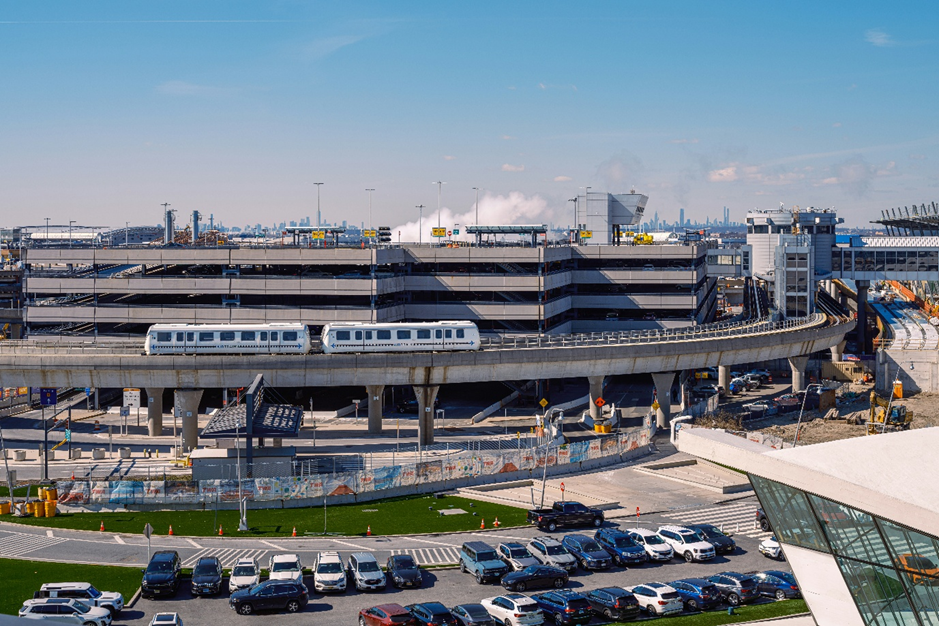 Modern airport infrastructure with elevated train system and parking facilities, representing large-scale mega projects